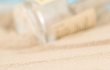 Transparent glass from a bottle sticking out of the sand on the beach