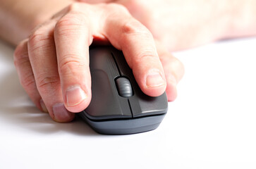 A computer mouse in a man's hand. White background.