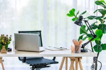 Interior architecture design workstation home office with wood table and adjustable chair with stationary equipment pencils laptop computer notebook textbooks lamp decor with tree basket flower pot