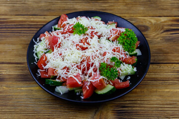Traditional Bulgarian Shopska salad on wooden table