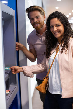 Young Tourist Couple Using Atm Early In The Morning