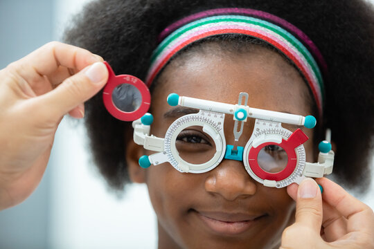 close up opthalmology trial frame with young woman african american eye test ophthalmological in optics clinic. woman checkup eye health with equipment opthalmology medical in hospital.