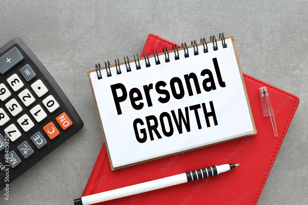 Poster personal growth text on open notepad on red notepad