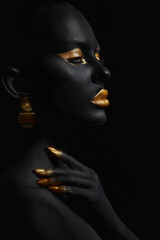 Beauty woman black skin color body art, gold makeup lips eyelids, fingertips nails in gold color paint. Professional gold makeup