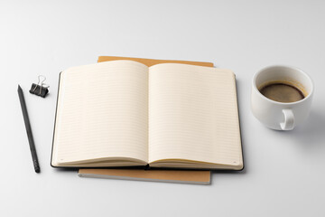 Cup of coffee and notepad on white background