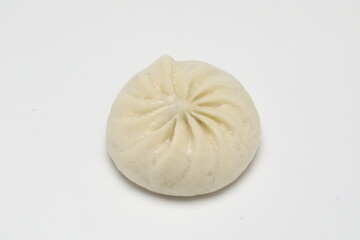 Delicious baozi, Chinese steamed meat bun is ready to eat on serving plate and steamer, close up, copy space product design concept.