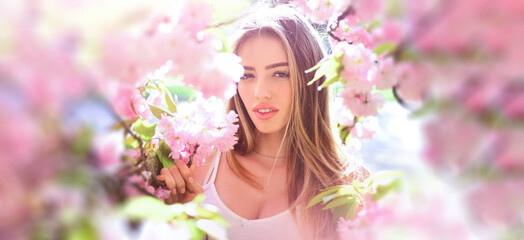 Obraz na płótnie Canvas Beauty spring woman face. Happy beautiful young girl relaxing in blossom park. Banner for header website design, copy space.