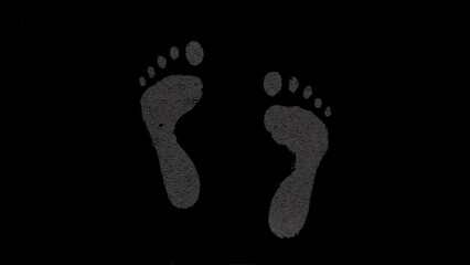 Inverted footprints printed on the wet glass on black background | foot care concept