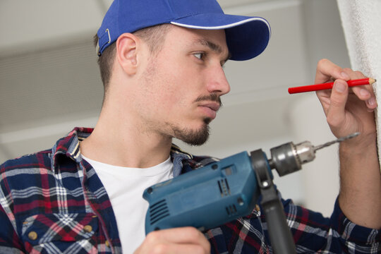 man holding drill and pencil in hands