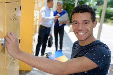 smiling male student at his locker