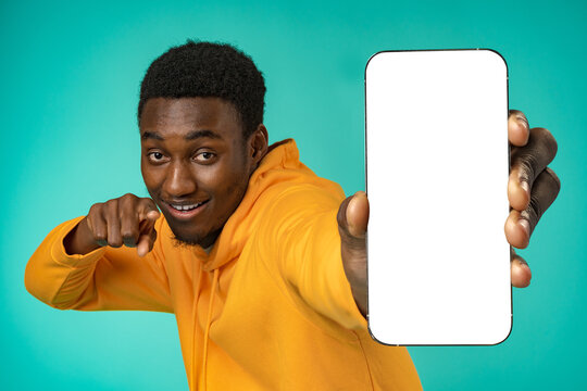 Smiling Casual Black Man Pointing At Blank White Cell Phone Screen In Studio