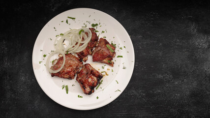 Grilled pork ribs with herbs on a dark background