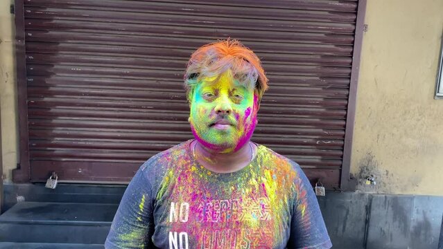 Indian man with beautiful multi color gulal on his face. Concept for Indian festival Holi. Shot in 4k
