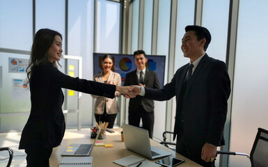 Business people shaking hands, finishing up a meeting.  Two business people holding hands, Two business people are agreeing on business together and shaking hands after a successful negotiation.