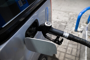 Refueling a car with diesel fuel. Selective focus. Refueling nozzle in the mouth of a gas tank at a...