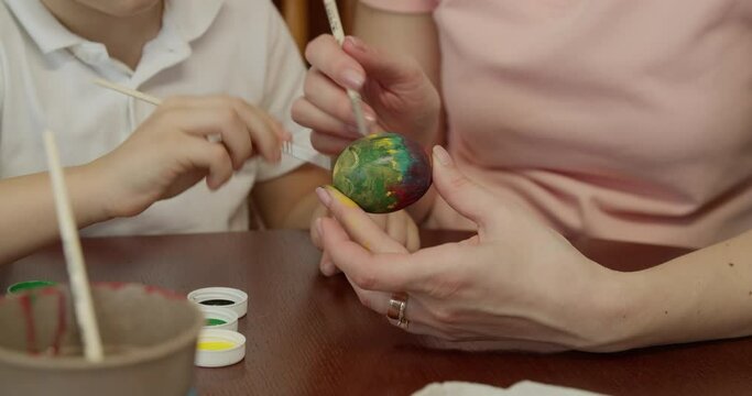 mother and son paint an egg. preparations for the Easter holiday