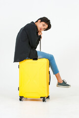 Portrait studio shot of Asian young LGBT gay bisexual homosexual male traveler model in casual black shirt and denim jeans sitting smiling on trolley luggage posing look at camera on white background