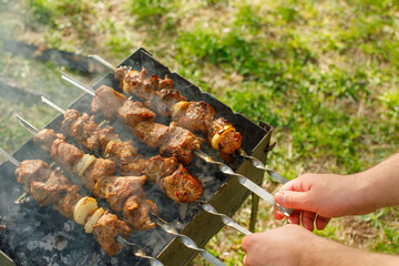 cook meat on the grill at a picnic. Meat on the grill at a summer picnic 