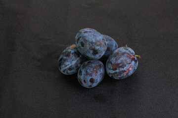 Ripe plum heap over background