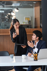 Female business leader explaining new project and discussing corporate business plan with her colleague.