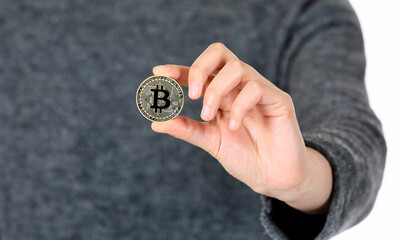 Fototapeta na wymiar A woman holding a bitcoin in her hand and holding it out