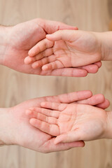Kids hands in the fathers palms. Parenting, friendship, guardianship, upbringing, parent-child relationship, family connection.