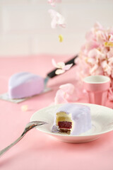 Mousse lavender heart-shaped cake on a pink background