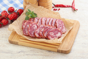 Sliced salami sausages over board