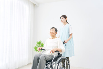 Fototapeta na wymiar 介護士と車椅子に乗る高齢者　室内