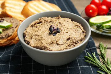 Bowl with delicious liver pate on wooden table, closeup