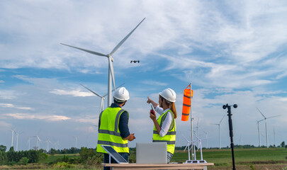 Engineers using meteorological and drone instrument collect data laptop to measure the wind speed, temperature,humidity and solar cell system on wind turbine station is sustainable energy concept. - obrazy, fototapety, plakaty