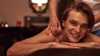 Obraz na płótnie Canvas Masseur doing back massage of relaxing male client