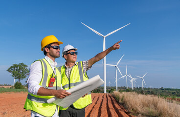 Engineer wearing uniform ,helmet hold document inspection work in wind turbine farms rotation to...