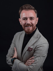 Fototapeta premium Portrait of a stylish elegant senior businessman with a beard and casual business clothes in photo studio isolated on dark background gesturing with hands