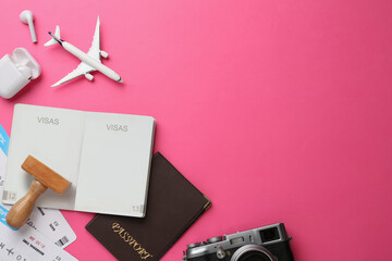 Flat lay composition with passports, stamp and flight tickets on pink background, space for text