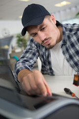 technician holding a screwdriver for fixing printer