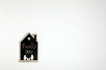 House shaped blackboard with phrase Family day and figures on white background. Space for text