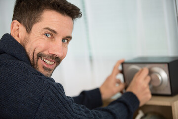 happy man listens at home to a radio broadcast