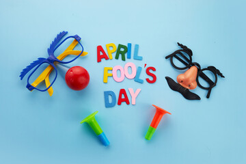 April Fools Day text and funny glasses and horns on blue background