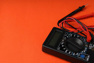 Multimeter on orange background, space for text