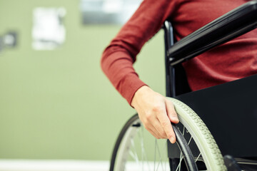 Close-up shot of unrecognizable young man with disability in wheelchair visiting contemporary art...