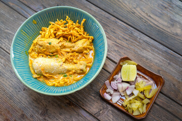 Thai Curry Noodles with Chicken in Thai when we call Khao Soi and Thai spicy egg noodle on wooden table.