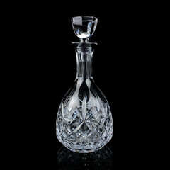 antique glass decanter with geometric pattern. retro decanter for alcohol on a black isolated...