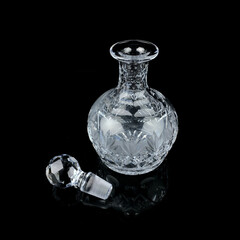 antique glass decanter with geometric pattern. retro decanter for alcohol on a black isolated background. engraved vintage decanter