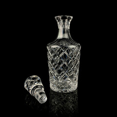 antique glass decanter with geometric pattern. retro decanter for alcohol on a black isolated...