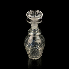 antique glass decanter with geometric pattern. retro decanter for alcohol on a black isolated...