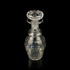 antique glass decanter with geometric pattern. retro decanter for alcohol on a black isolated background. engraved vintage decanter