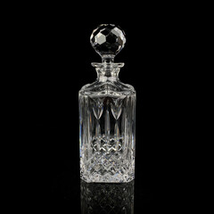 antique glass decanter with geometric pattern. retro decanter for alcohol on a black isolated background. engraved vintage decanter