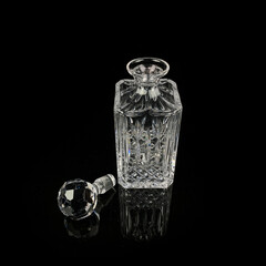 antique glass decanter with geometric pattern. retro decanter for alcohol on a black isolated background. engraved vintage decanter