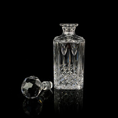 antique glass decanter with geometric pattern. retro decanter for alcohol on a black isolated background. engraved vintage decanter